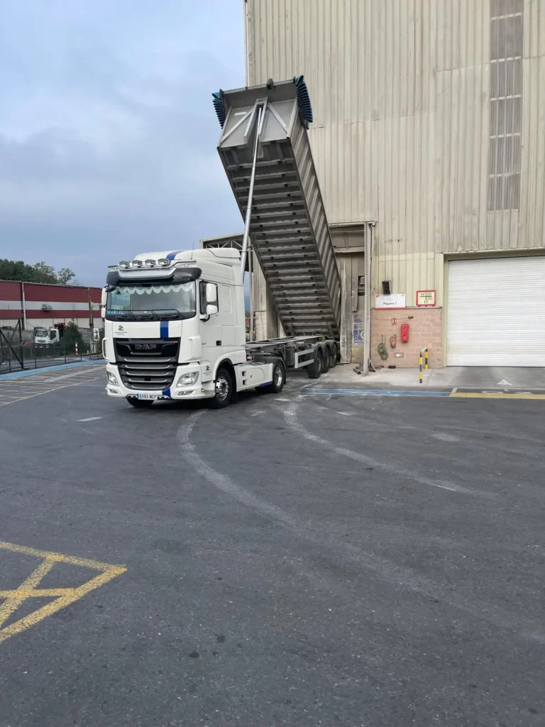 Camión de Transportes Jamardo con bañera basculante elevada durante una descarga en fábrica